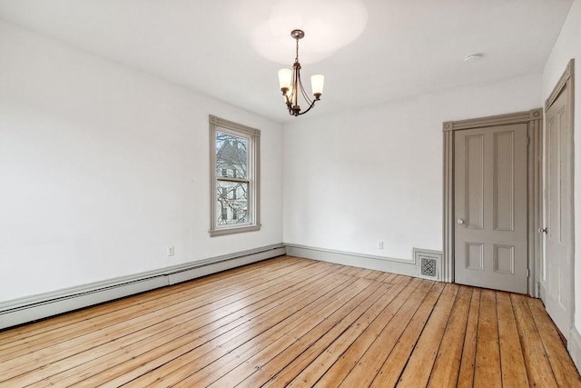 spare room featuring light wood finished floors, baseboard heating, a chandelier, and visible vents