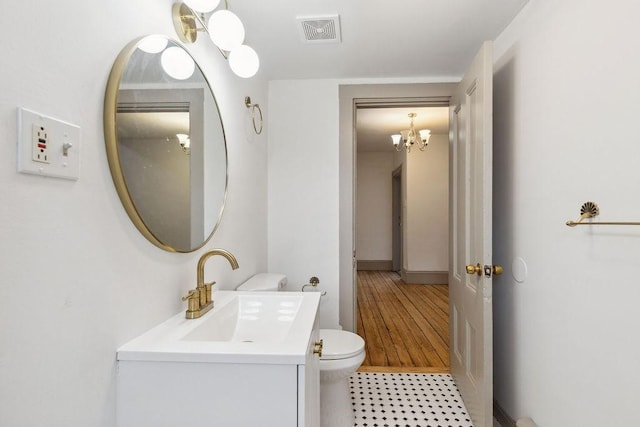 bathroom featuring visible vents, toilet, a notable chandelier, tile patterned flooring, and vanity