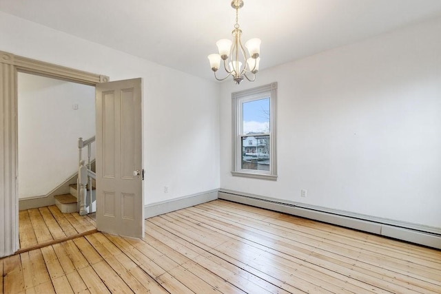 unfurnished room with stairway, baseboards, light wood finished floors, a baseboard radiator, and a notable chandelier