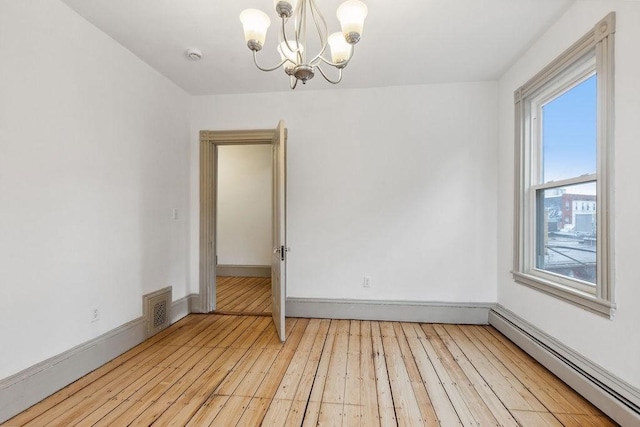 empty room featuring visible vents, a baseboard heating unit, light wood finished floors, baseboards, and a chandelier