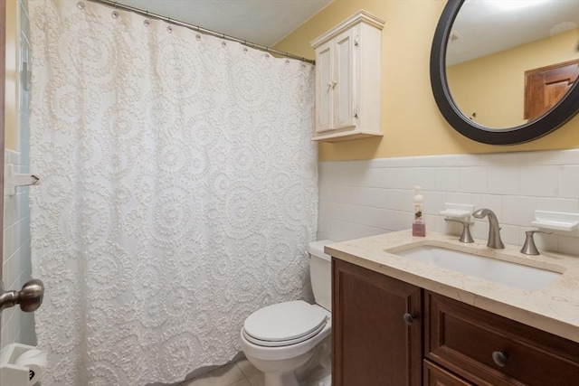 bathroom with toilet, a shower with shower curtain, tile walls, wainscoting, and vanity