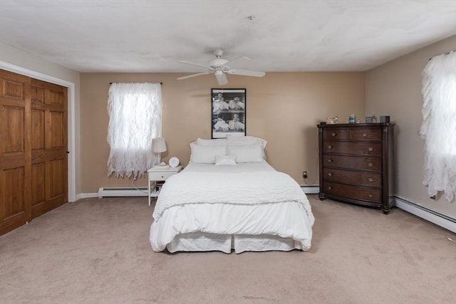 bedroom featuring a baseboard heating unit, ceiling fan, and light carpet