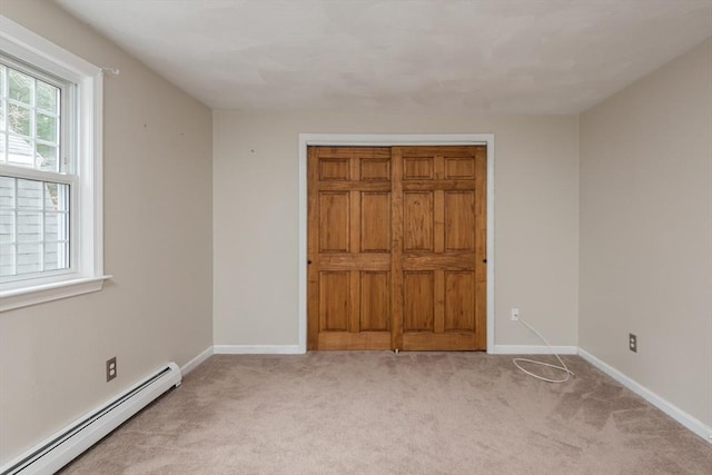 unfurnished bedroom with light colored carpet, baseboards, and a baseboard radiator