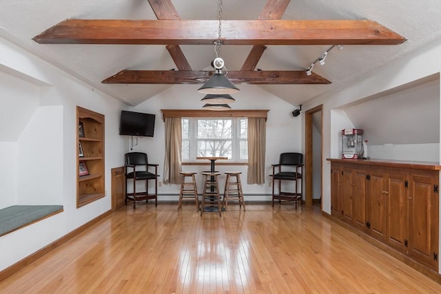 living area featuring built in shelves, baseboards, a baseboard radiator, vaulted ceiling with beams, and light wood-style floors