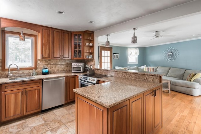 kitchen featuring a sink, stainless steel appliances, brown cabinets, and open floor plan