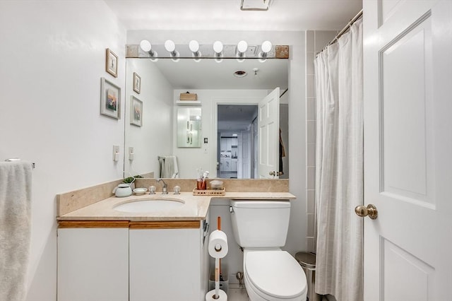 full bathroom featuring toilet, vanity, and curtained shower