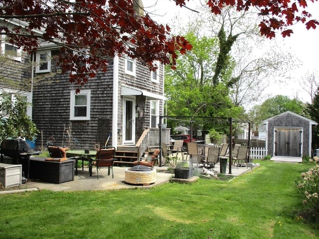 360 Russells Mills Rd, Dartmouth, MA 02748 - rear view of property with a fire pit, a patio area, a storage shed, and an outdoor structure