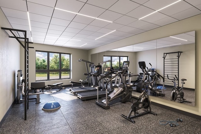 exercise room with a paneled ceiling and a wealth of natural light