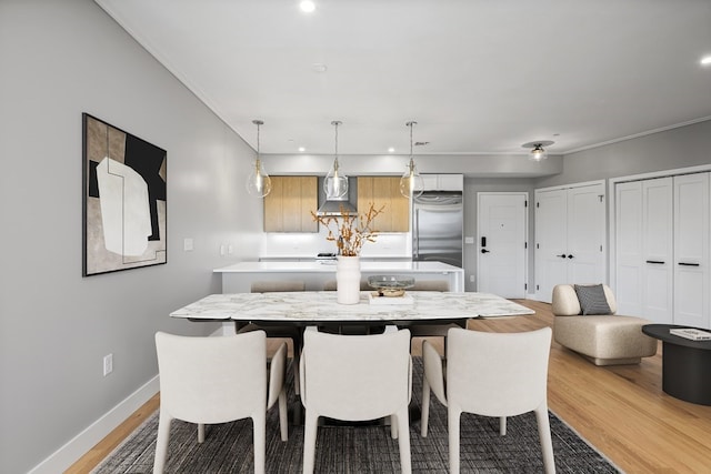 dining space with light hardwood / wood-style floors and crown molding