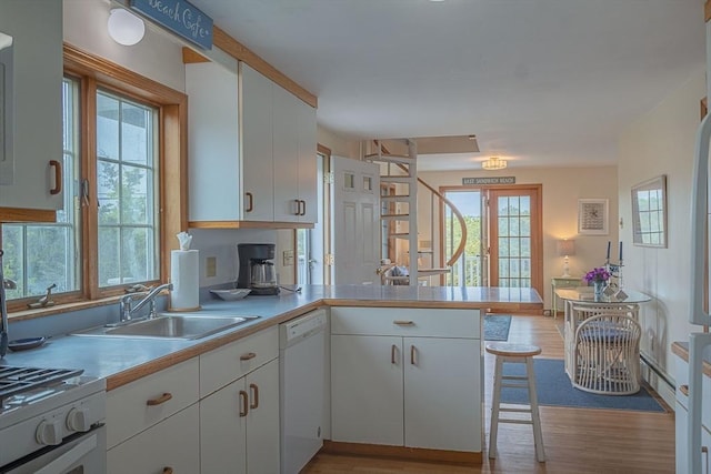 99 N Shore Blvd Unit 1, Sandwich, MA 02537 - kitchen featuring dishwasher, a peninsula, light wood finished floors, white cabinets, and light countertops