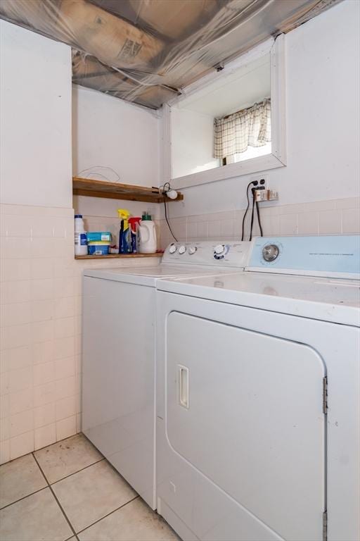 laundry area with separate washer and dryer and light tile patterned floors