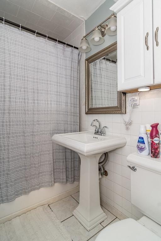 bathroom featuring sink, tile walls, tasteful backsplash, tile patterned floors, and toilet