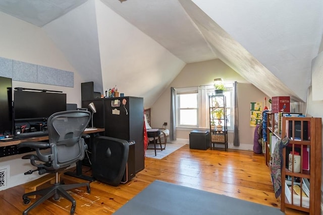 home office with lofted ceiling and light hardwood / wood-style floors