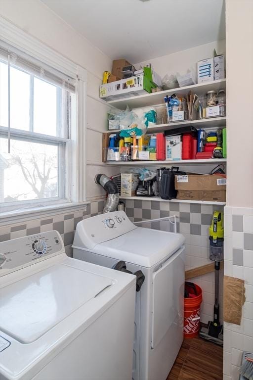 laundry area featuring separate washer and dryer and tile walls