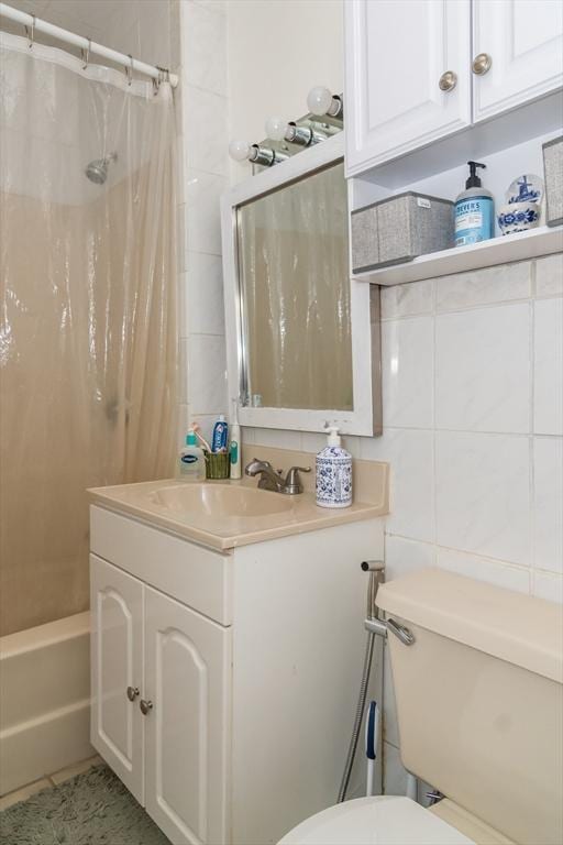 full bathroom with toilet, tile walls, vanity, shower / bath combo with shower curtain, and tile patterned flooring