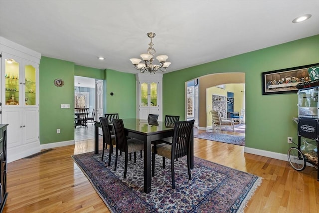 33 Gulf Hill Dr, Dartmouth, MA 02748 - dining room featuring light wood-style flooring, baseboards, arched walkways, and a chandelier