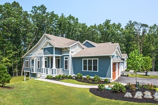 view of front facade with a porch, a garage, and a front lawn