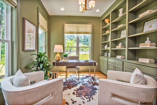 sitting room with an inviting chandelier, light hardwood / wood-style flooring, and crown molding