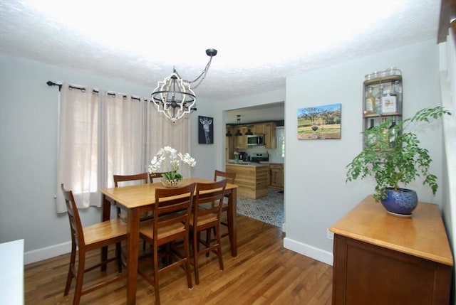 551 Indian Head St, Hanson, MA 02341 - dining room featuring a chandelier, light wood-type flooring, and a textured ceiling