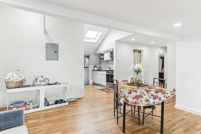 831 N Shore Rd, Revere, MA 02151 - dining room with electric panel, a skylight, light wood-style floors, lofted ceiling, and baseboards
