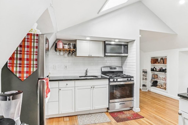 831 N Shore Rd, Revere, MA 02151 - kitchen featuring stainless steel appliances, a sink, light wood-type flooring, tasteful backsplash, and white cabinetry