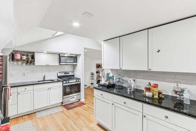 831 N Shore Rd, Revere, MA 02151 - kitchen with stainless steel appliances, a sink, backsplash, light wood-style flooring, and vaulted ceiling