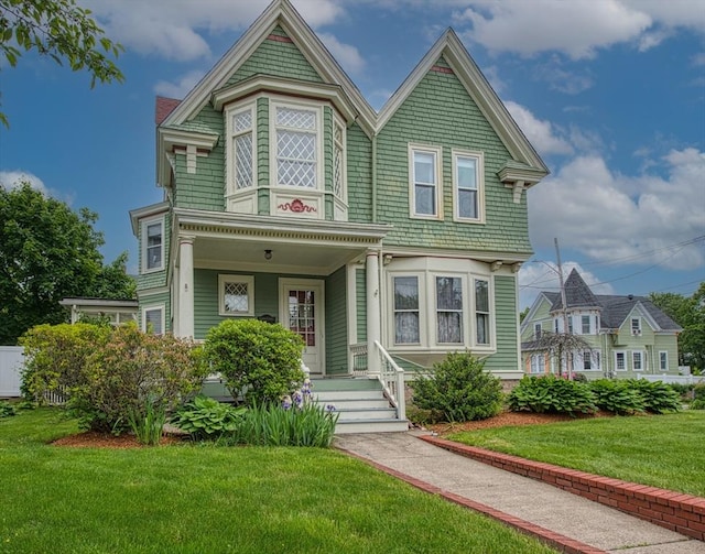 43 Ash St, Brockton, MA 02301 - victorian house featuring a front lawn and a porch