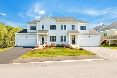 view of front of property with a garage and a front lawn