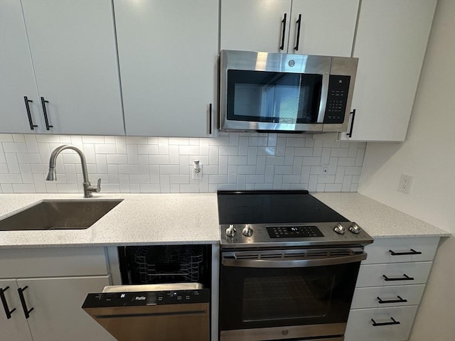 kitchen with decorative backsplash, sink, white cabinets, and appliances with stainless steel finishes