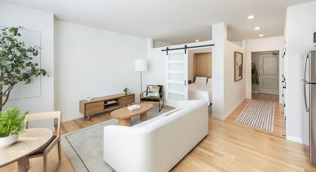 living room with light wood-type flooring and a barn door