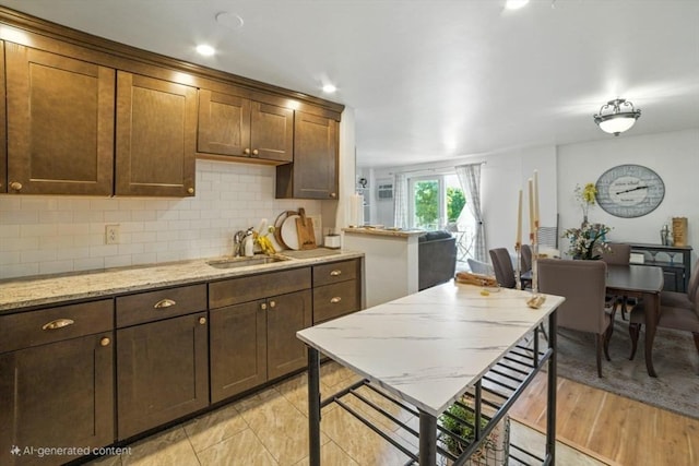 80 Main St Unit 20, Malden, MA 02148 - kitchen featuring decorative backsplash, light stone countertops, and light wood finished floors