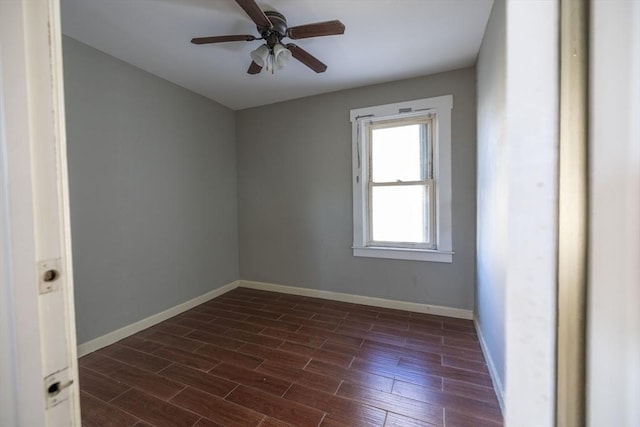 spare room featuring ceiling fan and dark wood-type flooring