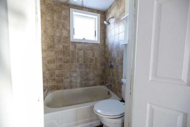 bathroom featuring tiled shower / bath combo and toilet