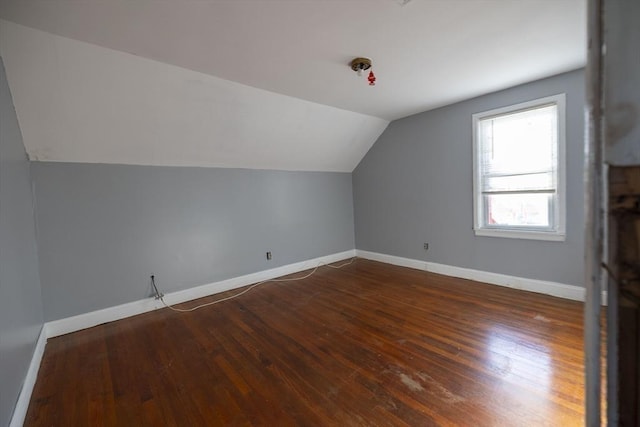 additional living space featuring lofted ceiling and dark wood-type flooring