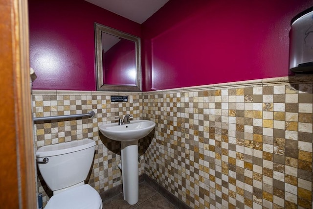 bathroom featuring tile patterned floors, tile walls, and toilet