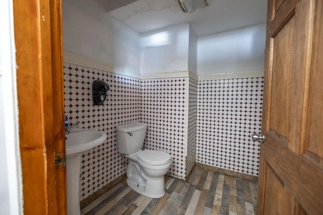 bathroom with toilet and tile walls