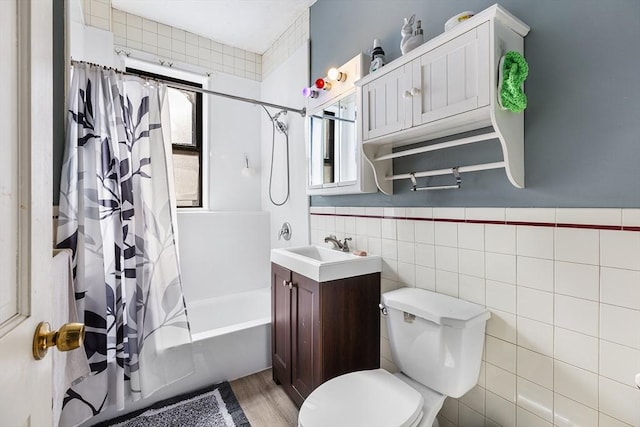 bathroom with tile walls, toilet, shower / tub combo, wood finished floors, and vanity