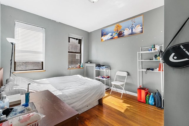 bedroom with baseboards and wood finished floors