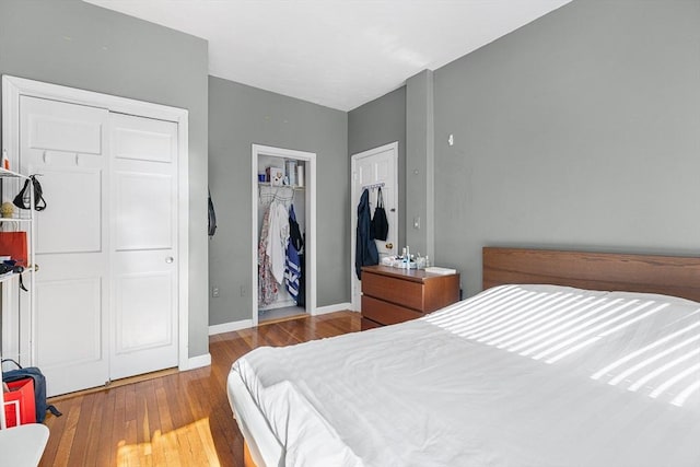 bedroom featuring wood finished floors, baseboards, and a closet