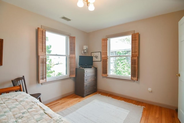 bedroom featuring multiple windows and light hardwood / wood-style flooring