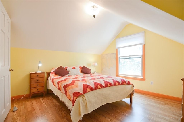 bedroom with hardwood / wood-style flooring and lofted ceiling