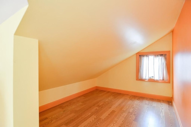 bonus room with light wood-type flooring and lofted ceiling