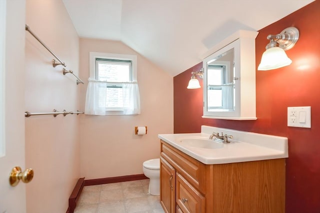 bathroom with toilet, vaulted ceiling, and vanity