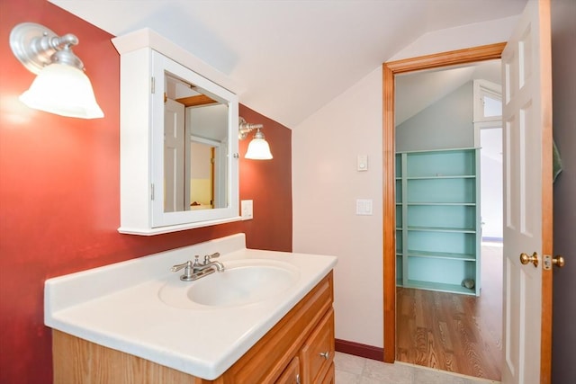 bathroom with lofted ceiling and vanity