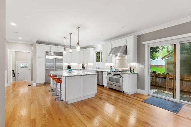 38 Paul Revere Rd, Lexington, MA 02421 - kitchen featuring premium appliances, ventilation hood, plenty of natural light, ornamental molding, and light countertops