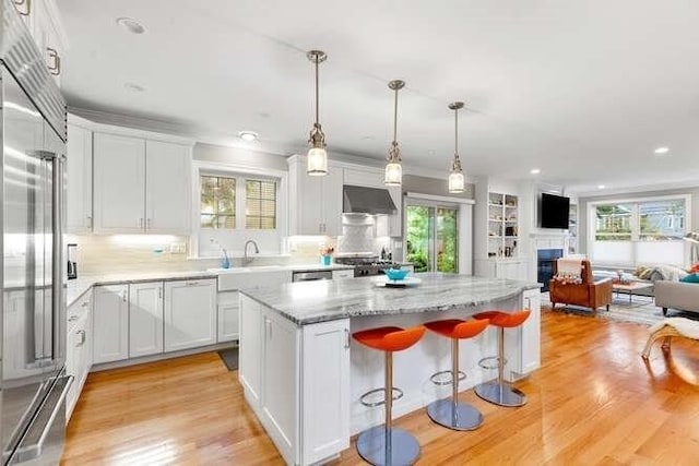 38 Paul Revere Rd, Lexington, MA 02421 - kitchen with built in fridge, a kitchen island, under cabinet range hood, plenty of natural light, and recessed lighting