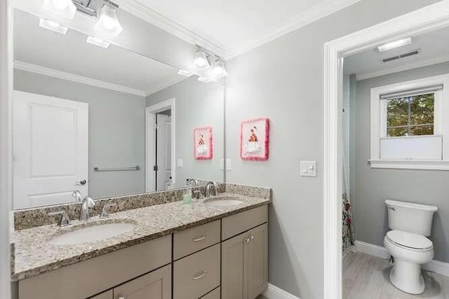 38 Paul Revere Rd, Lexington, MA 02421 - bathroom featuring baseboards, double vanity, toilet, ornamental molding, and wood finished floors