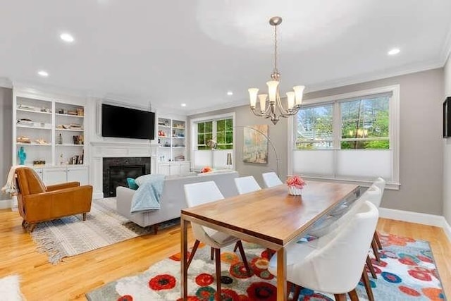 38 Paul Revere Rd, Lexington, MA 02421 - dining space with light wood-style flooring, a chandelier, recessed lighting, baseboards, and a glass covered fireplace