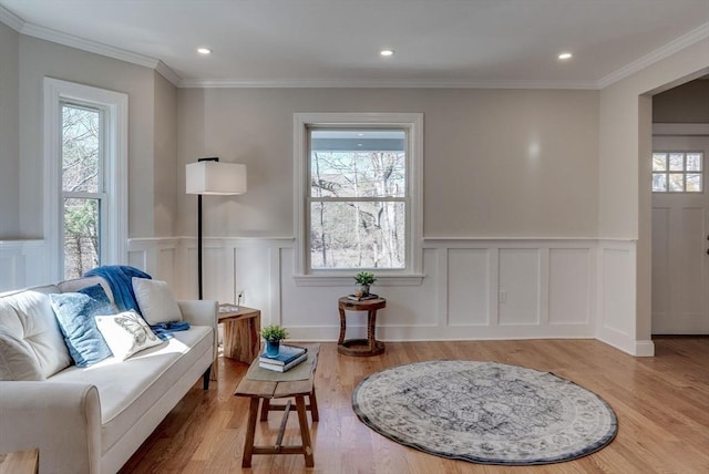 living area with a decorative wall, a wealth of natural light, and a wainscoted wall