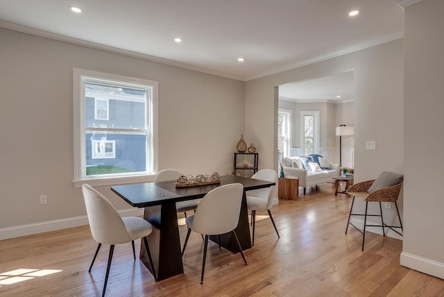 dining room with recessed lighting, light wood-type flooring, and crown molding